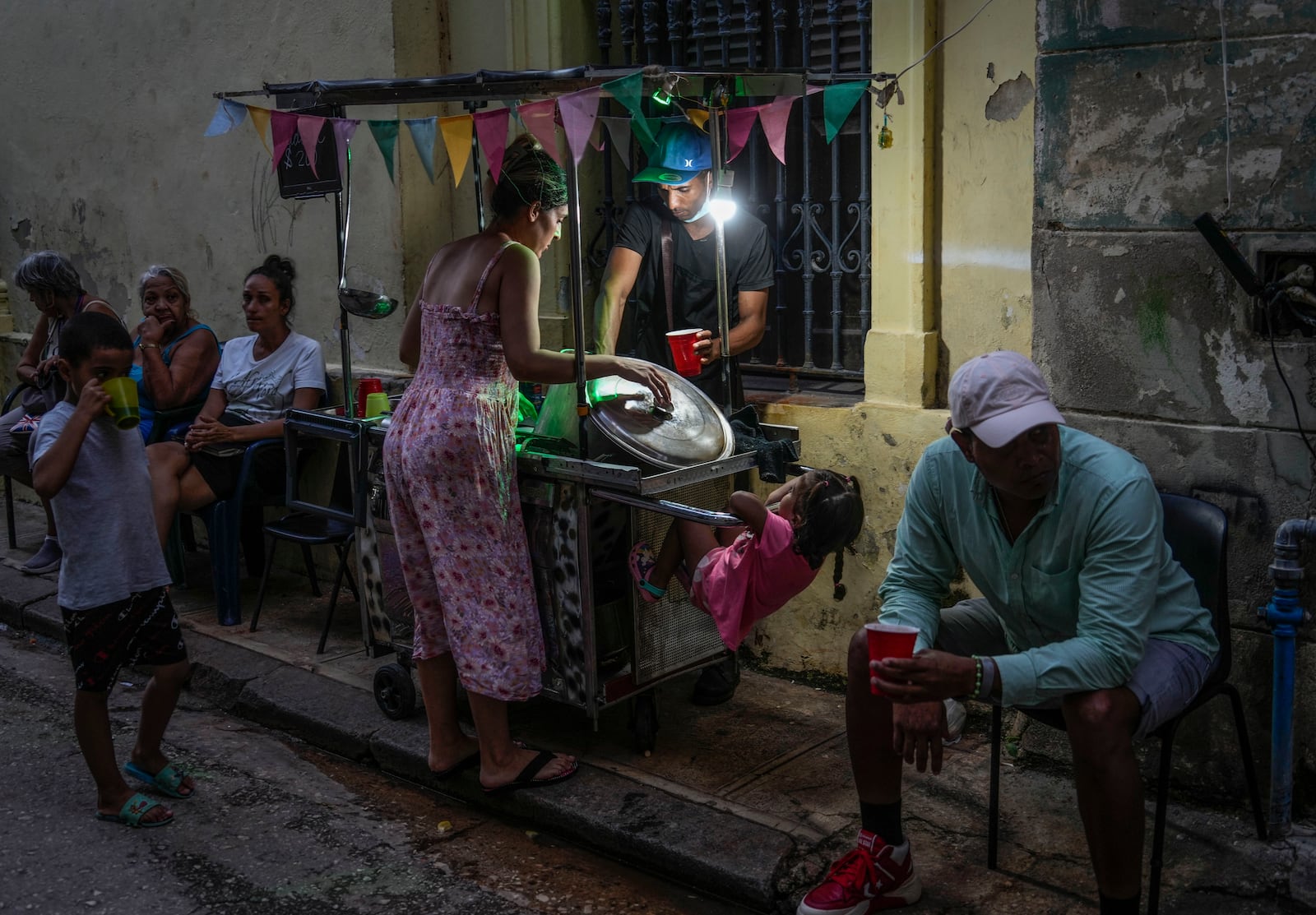 A woman buys soup from a street vendor in Havana, Monday, Oct. 21, 2024. (AP Photo/Ramon Espinosa)