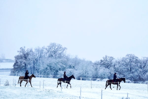 People ride horses after a snowfall at Sam Drinkwater's Granary Stables, Strensham, England, Tuesday, Nov. 19, 2024. (David Davies/PA via AP)