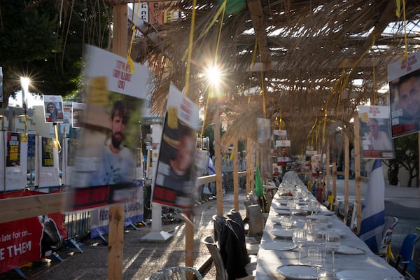 Posters of hostages held by the Hamas militant group in the Gaza Strip flutter in the breeze over a display of empty chairs for each hostage in Tel Aviv, Israel, Friday, Jan. 24, 2025. (AP Photo/Maya Alleruzzo)