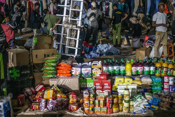 People shop at informal and illegal markets that pop up at night to avoid police raids in central Harare, Zimbabwe, Friday, Nov. 11, 2024. (AP Photo/Aaron Ufumeli)