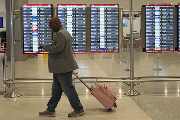 A traveler walks to his gate at Miami International Airport, Tuesday, Nov. 26, 2024, in Miami. (AP Photo/Marta Lavandier)