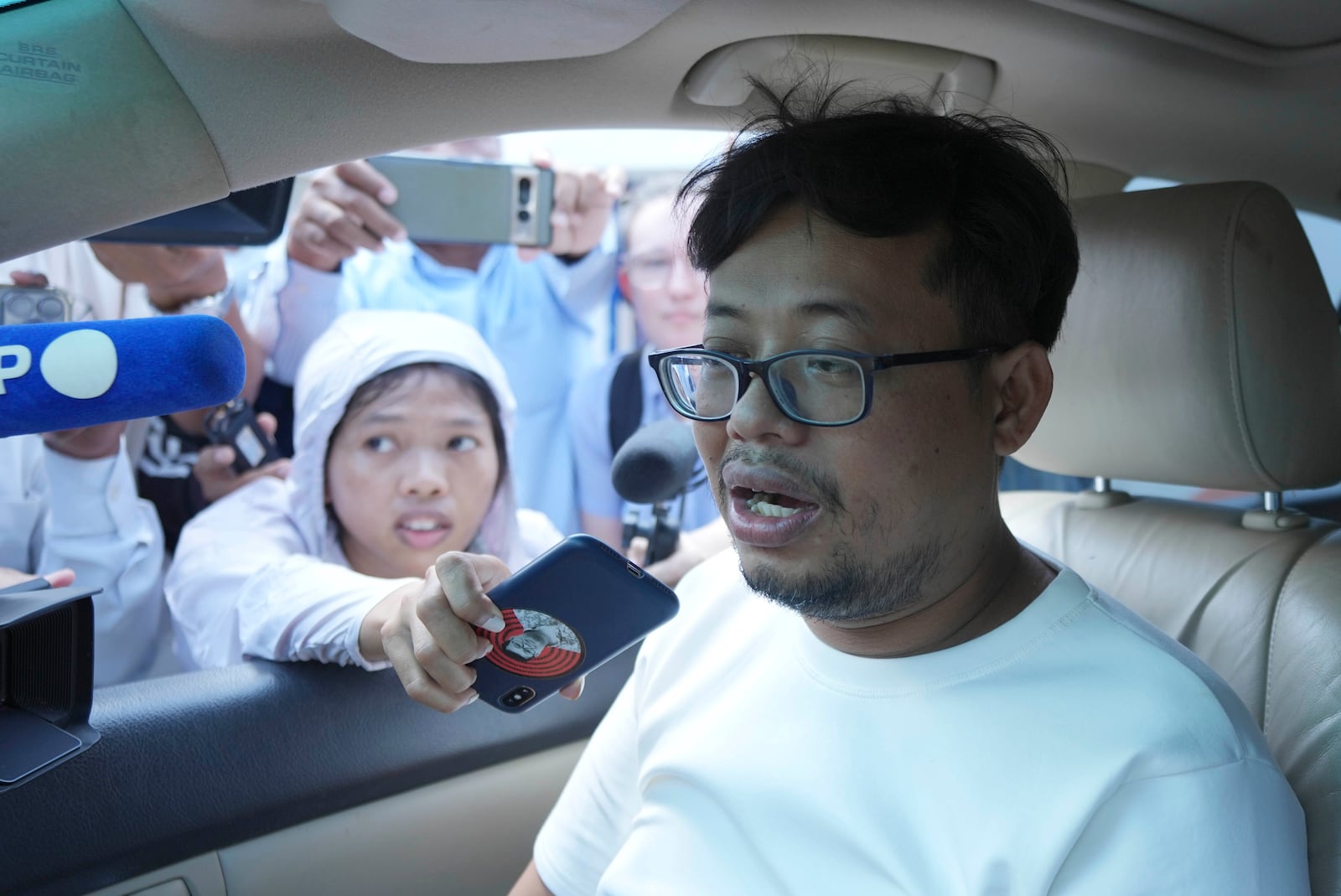 Cambodian freelance journalist Mech Dara, who was released on bail talks to the media from a car in front of the main provincial prison of Kendal Province, southern Phnom Penh, Cambodia, Thursday, Oct. 24, 2024. (AP Photo/Heng Sinith)