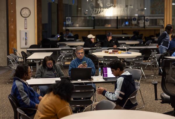 People gather at Sammamish City Hall on Sunday, Nov. 24, 2024, to power their devices and stay warm after last week's "bomb cyclone" wreaked havoc throughout Western Washington. (Nick Wagner/The Seattle Times via AP)