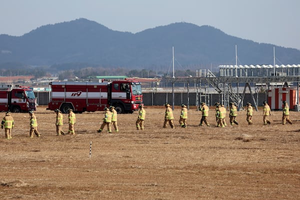 Firefighters and rescue team members work at Muan International Airport in Muan, South Korea, Sunday, Dec. 29, 2024. (Cho Nam-soo/Yonhap via AP)