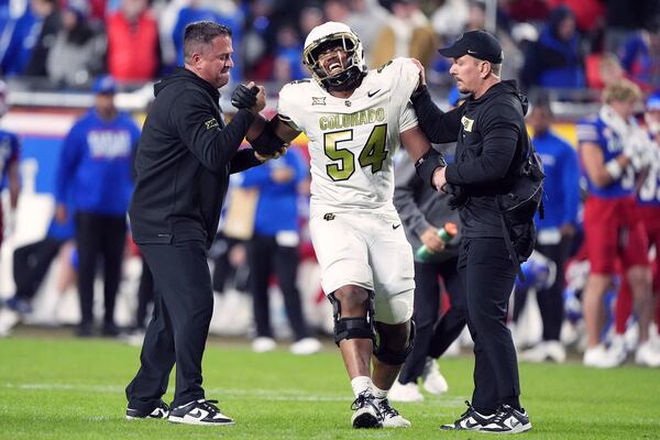 Colorado offensive tackle Phillip Houston (54) is helped off the field after getting injured during the second half of an NCAA college football game against Kansas, Saturday, Nov. 23, 2024, in Kansas City, Mo. (AP Photo/Charlie Riedel)