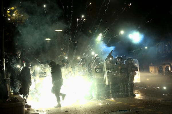 Demonstrators use petard against police as police blocked a street to prevent protesters rallying against the governments' decision to suspend negotiations on joining the European Union for four years, outside the parliament's building in Tbilisi, Georgia, early Saturday, Nov. 30, 2024. (AP Photo/Zurab Tsertsvadze)