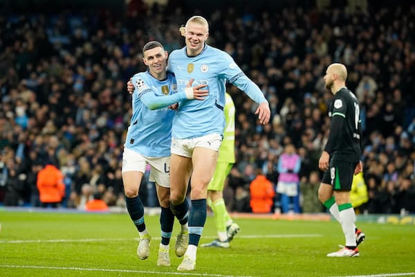 Manchester City's Erling Haaland, center, celebrates with Phil Foden, left, after scoring his side's third goal during the Champions League opening phase soccer match between Manchester City and Feyenoord at the Etihad Stadium in Manchester, England, Tuesday, Nov. 26, 2024. (AP Photo/Dave Thompson)