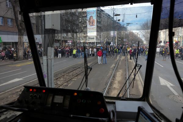 People stopping traffic, stand in silence during ongoing protests that erupted after a concrete canopy fell in the November and killed 15 people in Belgrade, Serbia, Wednesday, Jan. 29, 2025. (AP Photo/Darko Vojinovic)