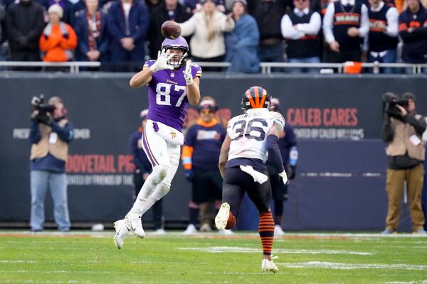 Minnesota Vikings tight end T.J. Hockenson (87) makes a catch past Chicago Bears safety Jonathan Owens (36) during overtime of an NFL football game Sunday, Nov. 24, 2024, in Chicago. (AP Photo/Charles Rex Arbogast)