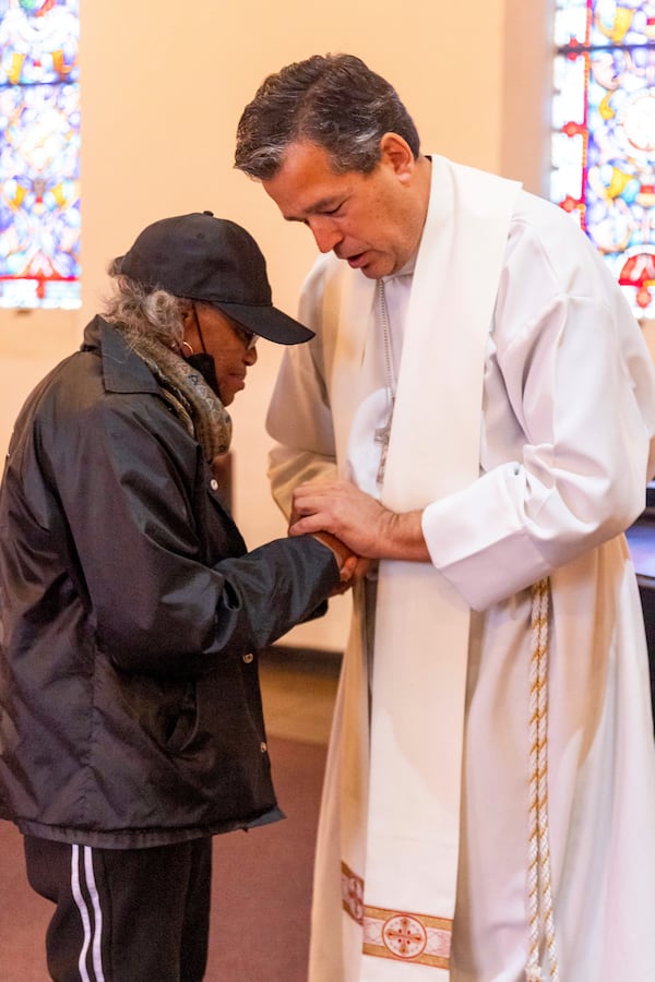 Rev. Dylan Littlefield, right, gives a blessing to a congregant during a religious service in the aftermath of the Eaton Fire at Trinity Lutheran Church Sunday, Jan. 12, 2025 in Pasadena, Calif. (AP Photo/Ethan Swope)