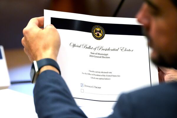 Republican Mississippi Northern District Public Service Commissioner Chris Brown holds his official ballot as a presidential elector after checking the box for President-elect Donald Trump, a step in formalizing President-elect Trump's White House victory last month over Vice President Kamala Harris Tuesday, Dec. 17, 2024, at the Mississippi State Capitol in Jackson. (AP Photo/Rogelio V. Solis)