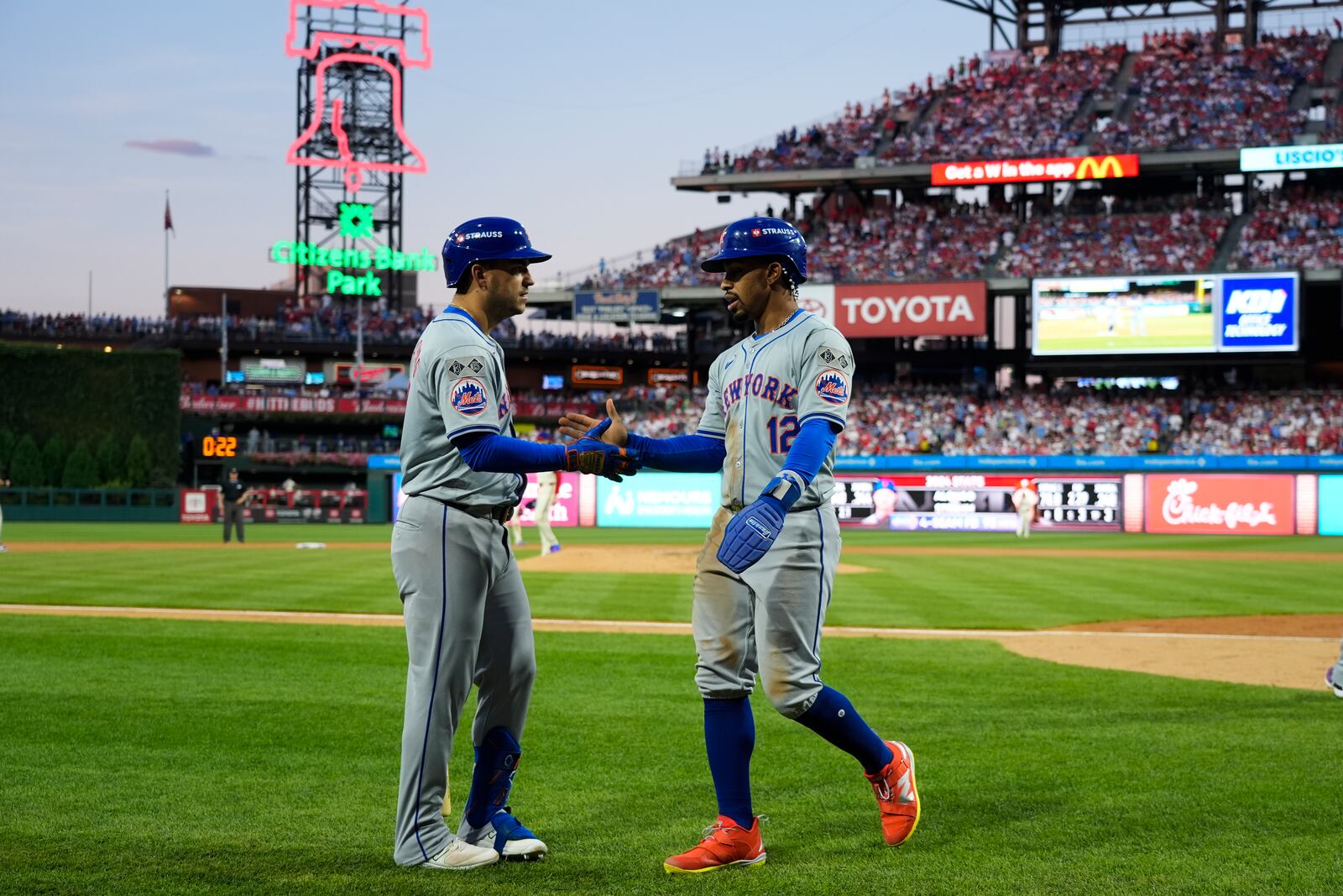 New York Mets' Francisco Lindor (12) celebrates with Jose Iglesias after scoring on a hit by Brandon Nimmo during the eighth inning of Game 1 of a baseball NL Division Series against the Philadelphia Phillies, Saturday, Oct. 5, 2024, in Philadelphia. (AP Photo/Chris Szagola)