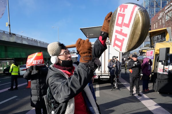 A protester beats a traditional Korean gong during a rally demanding the arrest of impeached South Korean President Yoon Suk Yeol near the presidential residence in Seoul, South Korea, Thursday, Jan. 9, 2025. The letters read "Dismiss." (AP Photo/Ahn Young-joon)