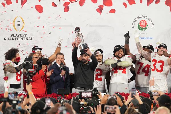 Ohio State head coach Ryan Day celebrates with the trophy alongside his team after winning the Rose Bowl College Football Playoff against Oregon, Wednesday, Jan. 1, 2025, in Pasadena, Calif. (AP Photo/Mark J. Terrill)