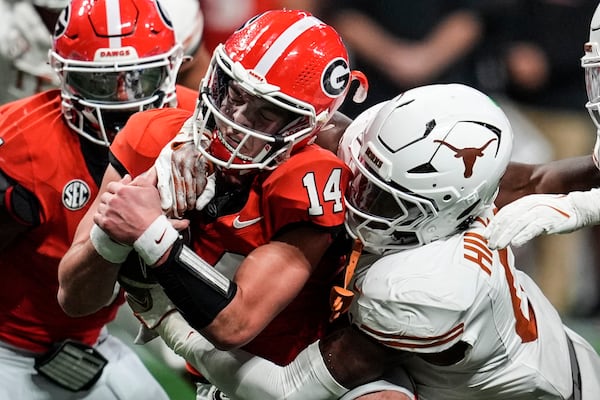 Texas linebacker Anthony Hill Jr. (0) hits Georgia quarterback Gunner Stockton (14) during the second half of the Southeastern Conference championship NCAA college football game, Saturday, Dec. 7, 2024, in Atlanta. (AP Photo/Mike Stewart)