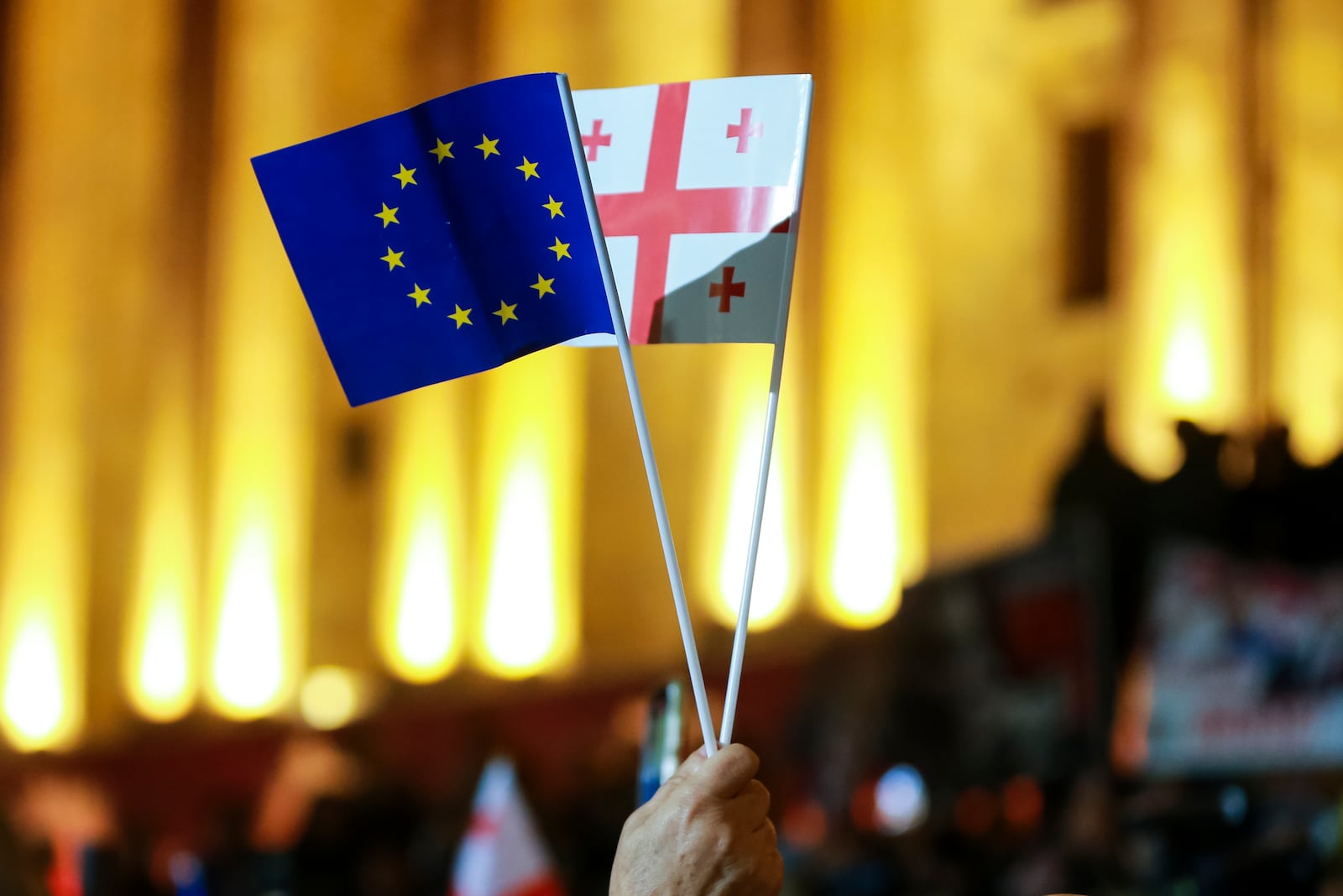 A demonstrator waves an EU and a Georgian national flags during an opposition protest against the results of the parliamentary election in Tbilisi, Georgia, Monday, Oct. 28, 2024. (AP Photo/Zurab Tsertsvadze)