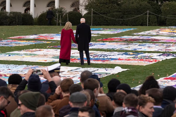 President Joe Biden, right, and first lady Jill Biden walk between AIDS Memorial Quilts spread over the South Lawn at the White House after a ceremony to commemorate World AIDS Day with survivors, their families and advocates, Sunday, Dec. 1, 2024, in Washington. (AP Photo/Manuel Balce Ceneta)