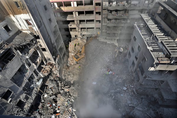 Rescue workers search for victims at the site of an Israeli airstrike that hit central Beirut, Lebanon, Saturday, Nov. 23, 2024. (AP Photo/Hussein Malla)