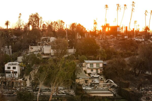 The Sun rises over homes destroyed by the Palisades Fire in the Pacific Palisades neighborhood of Los Angeles, Thursday, Jan. 16, 2025. (AP Photo/Damian Dovarganes)