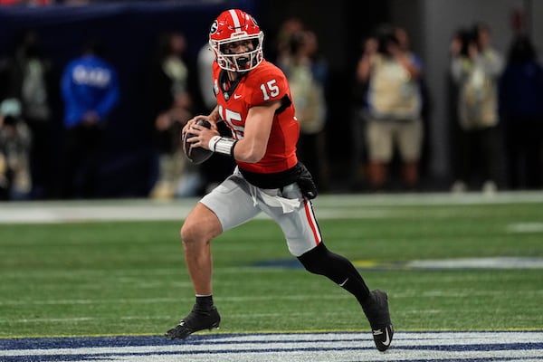 Georgia quarterback Carson Beck (15) runs out of the pocket against Texas during the first half of the Southeastern Conference championship NCAA college football game, Saturday, Dec. 7, 2024, in Atlanta. (AP Photo/John Bazemore)