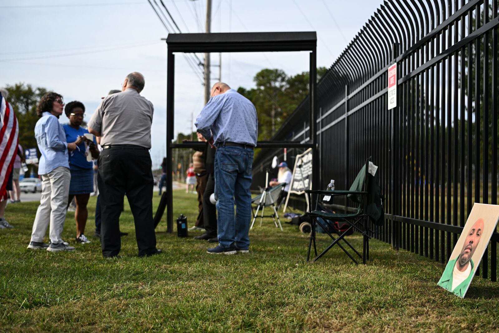 A photo of Richard Moore, right, is propped along a fence as protestors gather prior to Moore's scheduled execution, Friday, Nov. 1, 2024, outside of Broad River Correctional Institution in Columbia, S.C. (AP Photo/Matt Kelley)