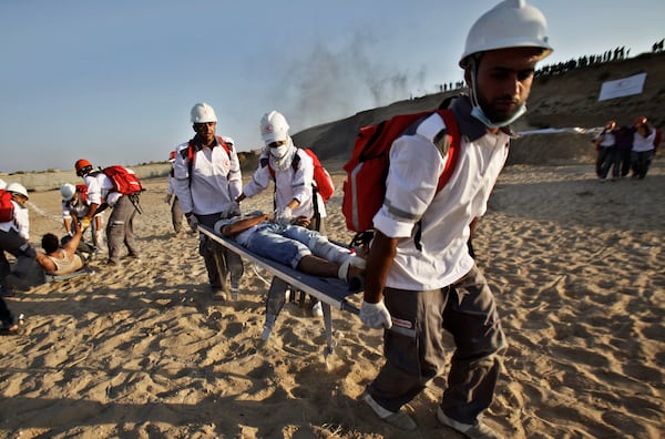 FILE- Medics from the Palestine Red Crescent Society and volunteers at the National Disaster Response Team "NDRT" , participated in a drill during a graduation ceremony of medics, in Mughraqa, central Gaza Strip, Sept. 5, 2013. (AP Photo/Adel Hana), File)