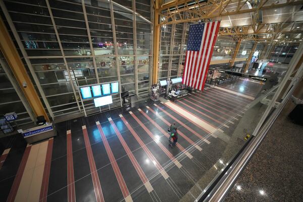 People walk through the virtually empty Ronald Reagan Washington National Airport, Wednesday, Jan. 29, 2025, in Arlington, Va. (AP Photo/Julio Cortez)