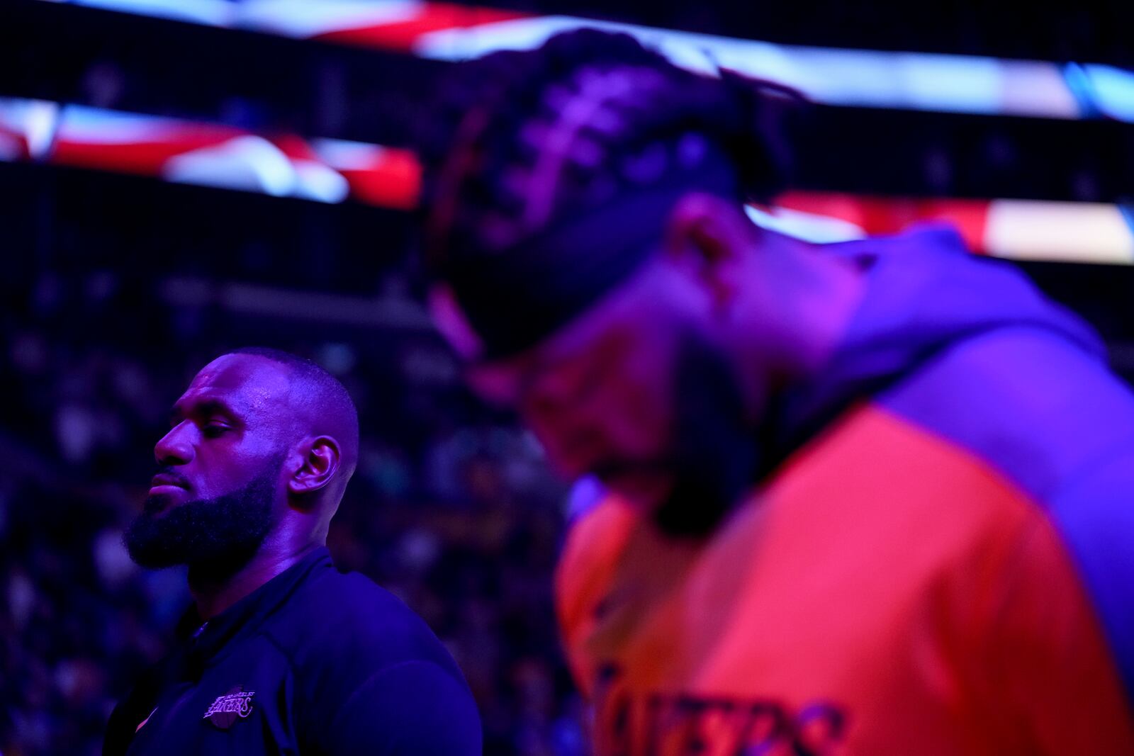 Los Angeles Lakers forwards LeBron James, left, and Anthony Davis, right, listen to the national anthem before an NBA basketball game against the Phoenix Suns in Los Angeles, Friday, Oct. 25, 2024. (AP Photo/Eric Thayer)