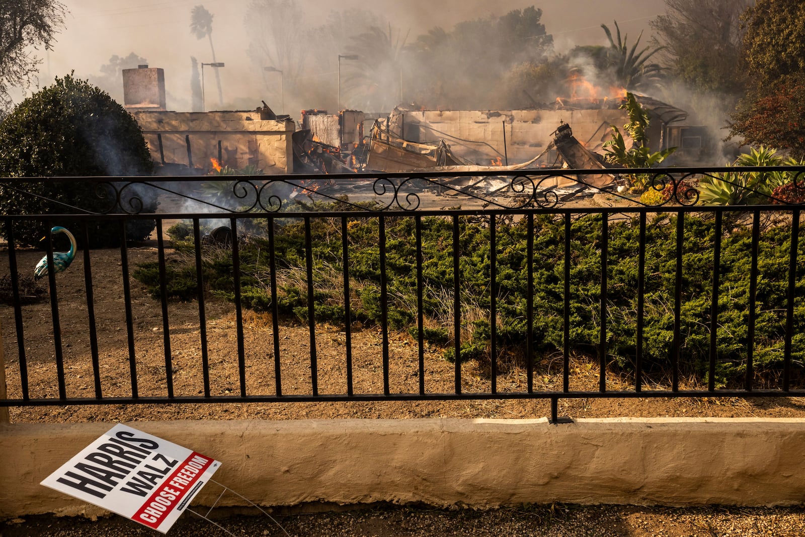 A political sign sits in front of a destroyed home in the Mountain fire, Wednesday, Nov. 6, 2024, near Camarillo, Calif. (AP Photo/Ethan Swope)