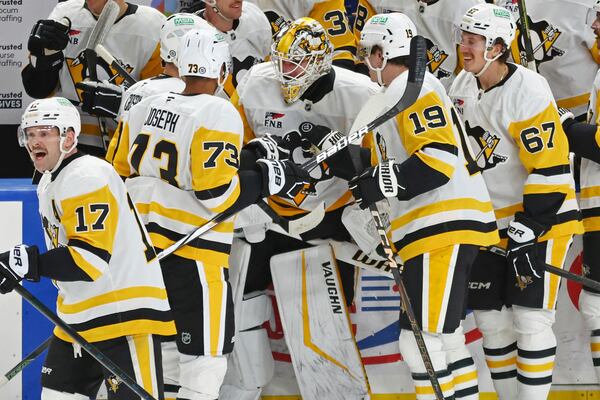 Pittsburgh Penguins goaltender Alex Nedeljkovic, center, celebrates with teammates after scoring during the third period of an NHL hockey game against the Buffalo Sabres, Friday, Jan. 17, 2025, in Buffalo, N.Y. (AP Photo/Jeffrey T. Barnes)