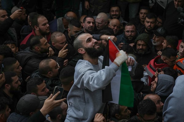 Palestinian prisoners are greeted by a crowd after being released from Israeli prison following a ceasefire agreement, in the West Bank city of Ramallah, Saturday, Jan. 25, 2025.(AP Photo/Mahmoud Illean)