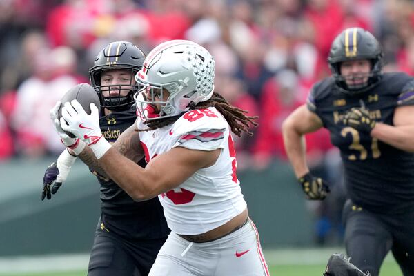 Ohio State tight end Gee Scott Jr. catches a deep pass from quarterback Will Howard as Northwestern linebacker Greyson Metz defends during the first half of an NCAA college football game at Wrigley Field on Saturday, Nov. 16, 2024, in Chicago. (AP Photo/Charles Rex Arbogast)