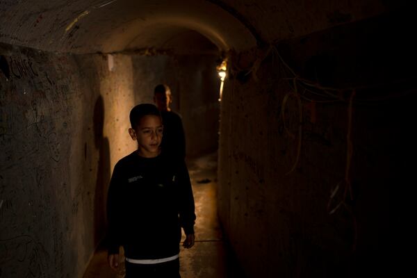 Boys walk through a replica of a Gaza tunnel in Tel Aviv, Israel, as Israel's security Cabinet recommended approval of a ceasefire deal after Prime Minister Benjamin Netanyahu confirmed an agreement had been reached that would pause the 15-month war with Hamas in Gaza and release dozens of hostages held by militants there, Friday, Jan. 17, 2025. (AP Photo/Maya Alleruzzo)