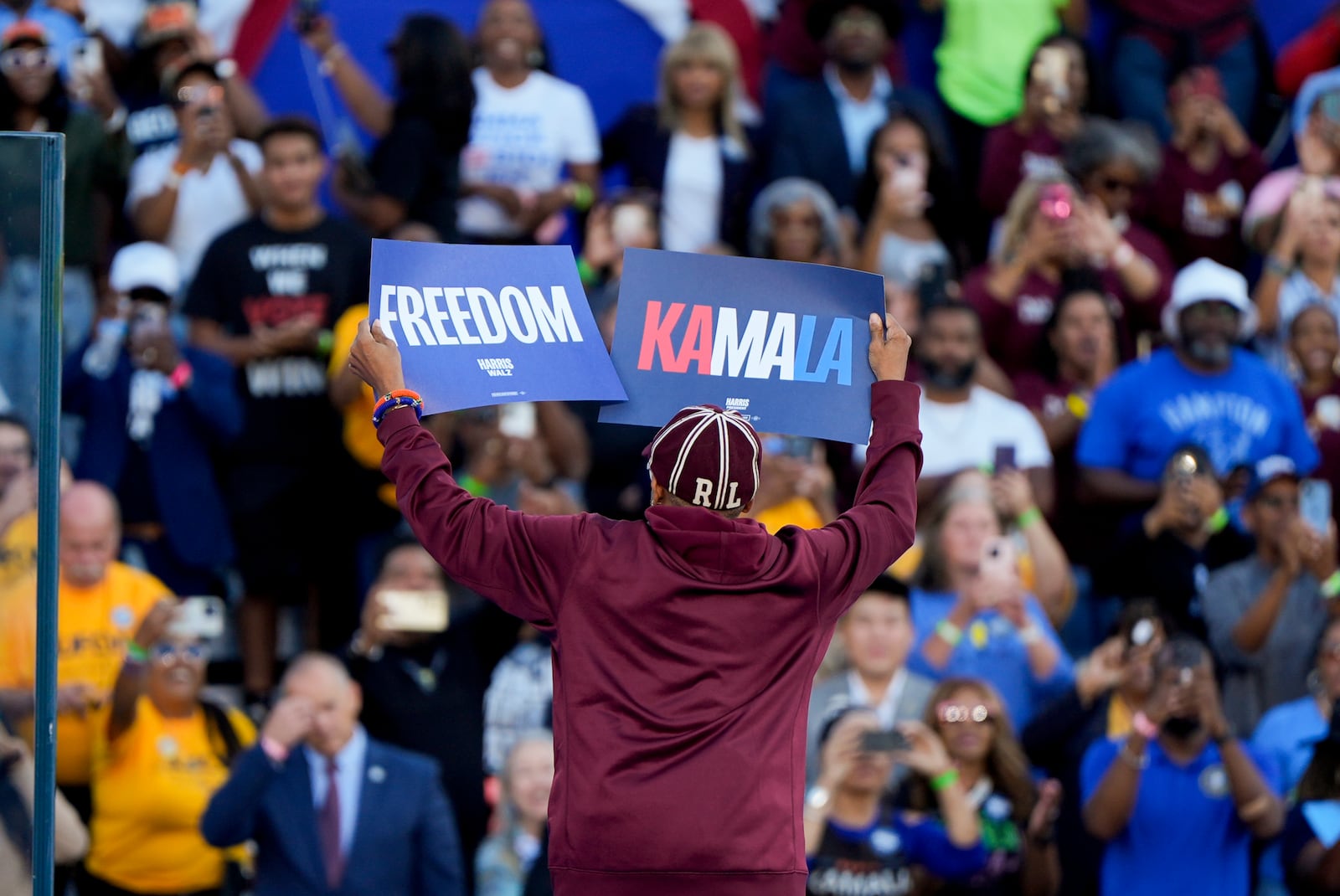 Spike Lee holds signs while on stage at a campaign rally supporting Democratic presidential nominee Vice President Kamala Harris, Thursday, Oct. 24, 2024, in Clarkston, Ga. (AP Photo/Mike Stewart)