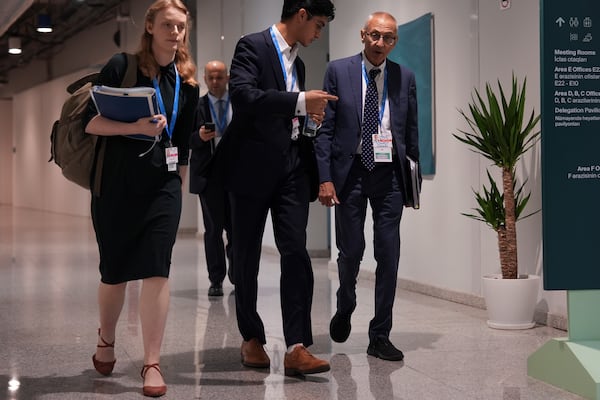 John Podesta, U.S. climate envoy, right, walks through the hallways of the COP29 U.N. Climate Summit in the early hours of Saturday, Nov. 23, 2024, in Baku, Azerbaijan. (AP Photo/Joshua A. Bickel)