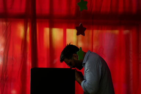 A voter chooses his preference at polling station in the presidential run-off election in Montevideo, Uruguay, Sunday, Nov. 24, 2024. (AP Photo/Natacha Pisarenko)