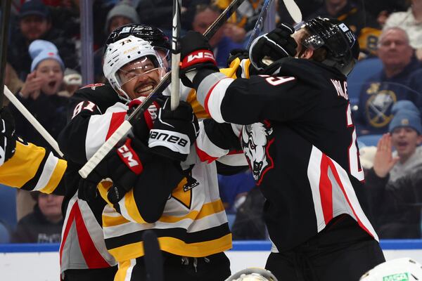 Pittsburgh Penguins defenseman P.O Joseph (73) and Buffalo Sabres left wing Beck Malenstyn (29) battle after the whistle during the first period of an NHL hockey game Friday, Jan. 17, 2025, in Buffalo, N.Y. (AP Photo/Jeffrey T. Barnes)