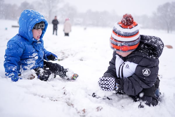 Maddox Chappell, 4, left, and his brother River Chappell, 6, right, play in the snow Friday, Jan. 10, 2025, in Nashville, Tenn. (AP Photo/George Walker IV)