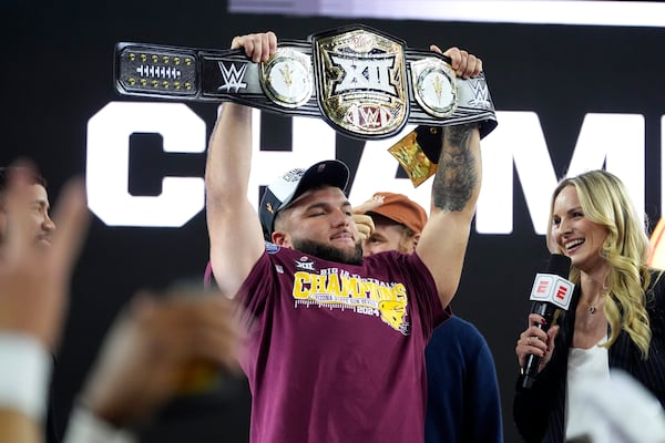 Arizona State running back Cam Skattebo (4) holds up the most valuable player trophy after the team's win against Iowa State in the Big 12 Conference championship NCAA college football game, in Arlington, Texas, Saturday Dec. 7, 2024. (AP Photo/Julio Cortez)