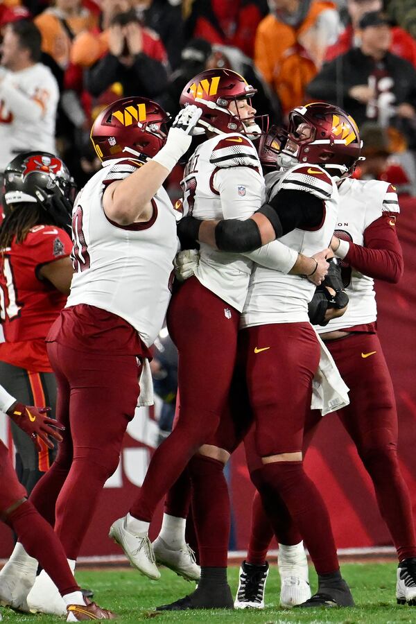 Washington Commanders place kicker Zane Gonzalez, middle, is congratulated by teammates after kicking the game winning field goal against the Tampa Bay Buccaneers during the second half of an NFL wild-card playoff football game in Tampa, Fla., Sunday, Jan. 12, 2025. (AP Photo/Jason Behnken)