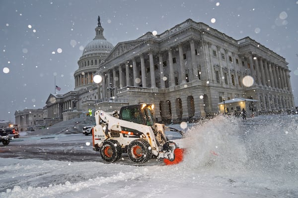 Workers clear the plaza at the Capitol as snow falls ahead of a joint session of Congress to certify the votes from the Electoral College in the presidential election, in Washington, Monday, Jan. 6, 2025. (AP Photo/J. Scott Applewhite)