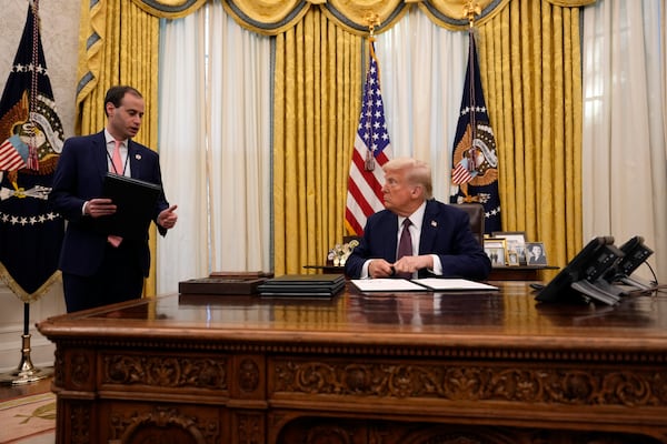 President Donald Trump talks with White House staff secretary Will Scharf as he signs executive orders in the Oval Office of the White House, Thursday, Jan. 23, 2025, in Washington. (AP Photo/Ben Curtis)