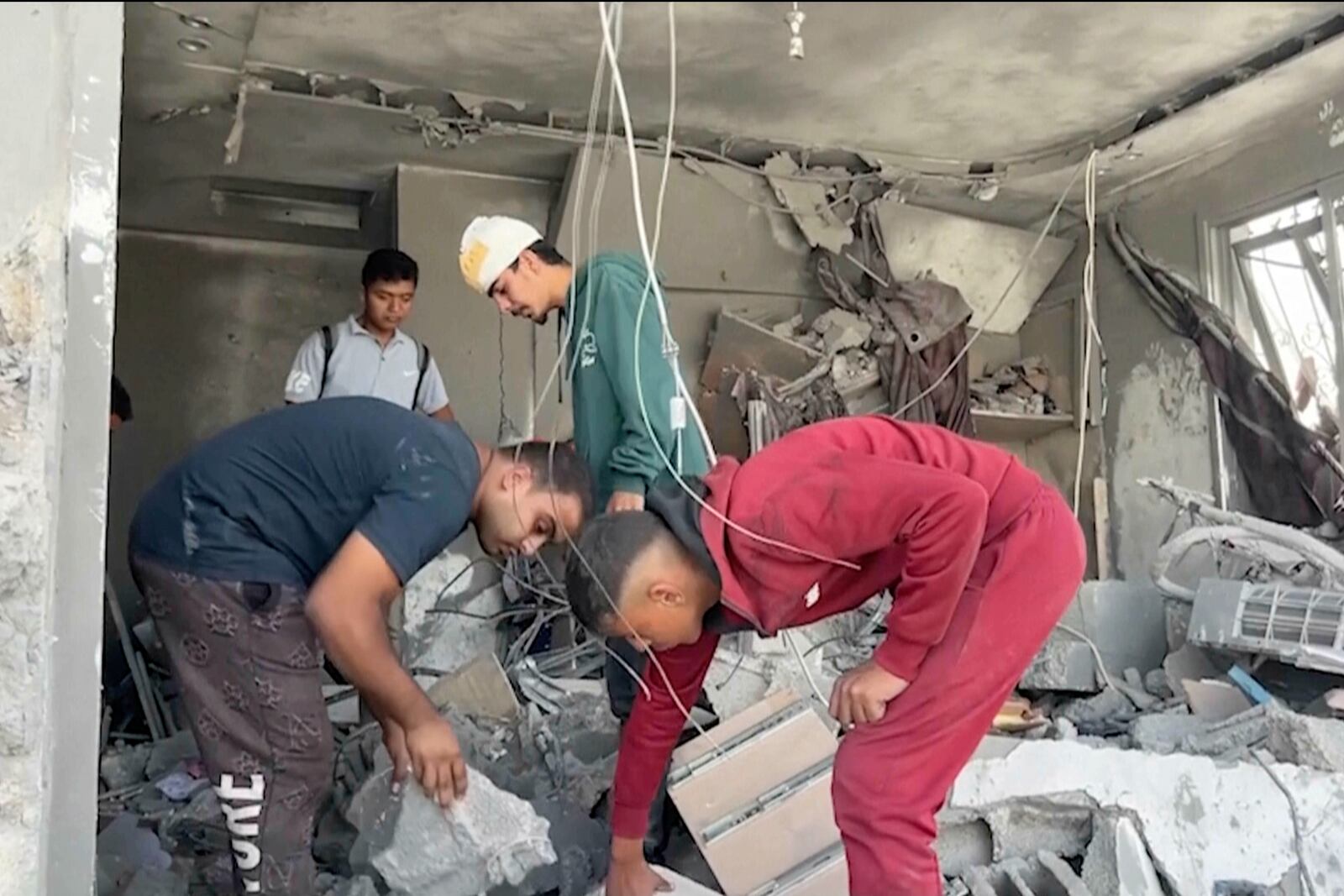 Palestinians sift through the rubble of a building destroyed by Israeli airstrikes in the city of Khan Younis, southern Gaza Strip, Friday, Oct. 25, 2024. (AP Photo)