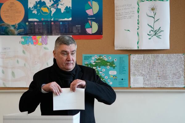 Croatia's President Zoran Milanovic prepares his ballot during a presidential election at a polling station in Zagreb, Croatia, Sunday, Dec. 29, 2024. (AP Photo/Darko Bandic)