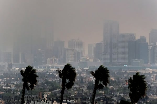 High winds blow as thick smoke from wildfires shrouds downtown Los Angeles on Wednesday, Jan. 8, 2025. (AP Photo/Richard Vogel)