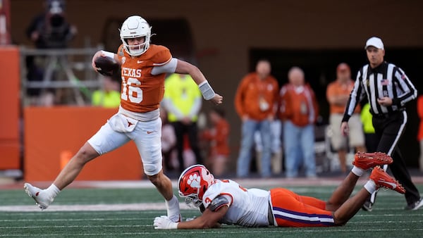 Texas quarterback Arch Manning (16) tries to break a tackle by Clemson defensive end T.J. Parker (3) during the second half in the first round of the College Football Playoff, Saturday, Dec. 21, 2024, in Austin, Texas. (AP Photo/Eric Gay)