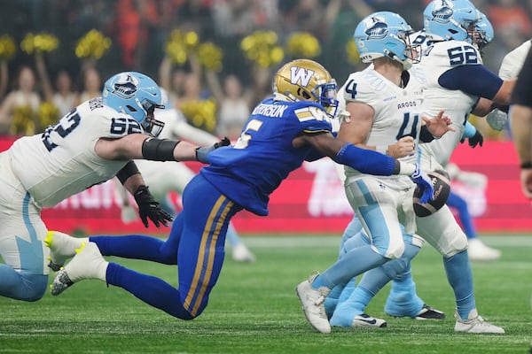 Winnipeg Blue Bombers' Willie Jefferson (5) strips the ball from Toronto Argonauts quarterback Nick Arbuckle (4) during the the second half of a CFL football game at the 111th Grey Cup in Vancouver, British Columbia, Sunday, Nov. 17, 2024. (Nathan Denette/The Canadian Press via AP)