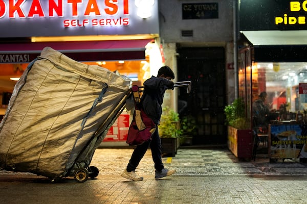 A boy pulls a cart as he scavenges for items in the Kadikoy district in Istanbul, Turkey, Saturday, Dec. 7, 2024. (AP Photo/Francisco Seco)