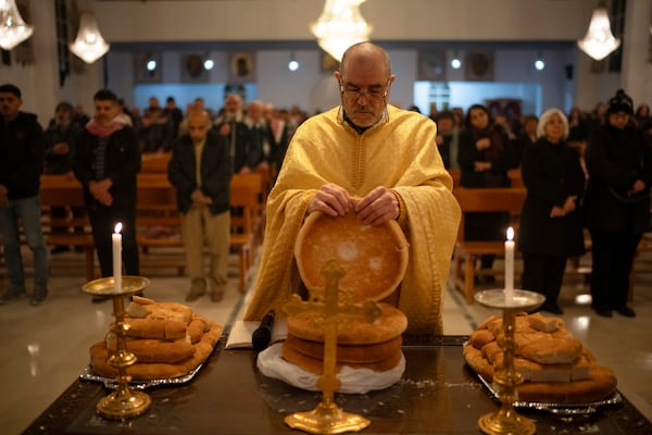 Priest Jalal Ghazal attends a Christmas mass at the church of St. George, in Maaloula, some 60 km northern Damascus, Syria, Tuesday, Dec. 24, 2024. (AP Photo/Leo Correa)