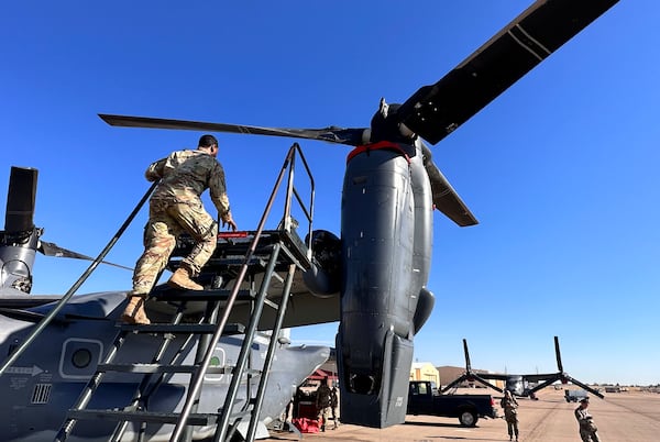 Master Sgt. Frank Williams, the production superintendent of the 20th Special Operations aircraft maintenance squadron at Cannon Air Force Base, N.M., climbs a ladder to show where hydraulic lines at the joint of the rotating engine and transmission need to be checked on the Osprey after flights, Oct. 8, 2024. (AP Photo/Tara Copp)